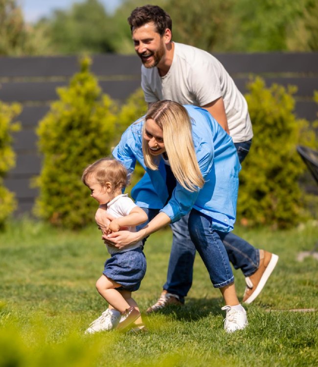 rodzice bawią się z dzieckiem na łące